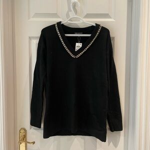 Woman’s black v neck sweater with gold
Chain


Bin 5
